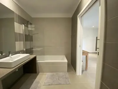 a bathroom with a sink and a bath tub and a sink at Albufeira Malpique Beach Apartment in Albufeira