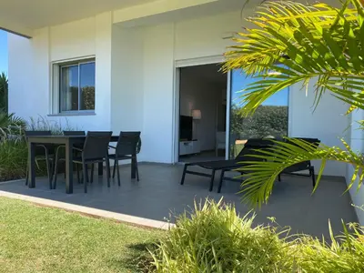 a patio with a black table and chairs at Albufeira Malpique Beach Apartment in Albufeira
