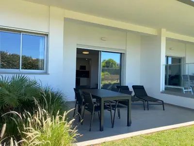 a patio with a black table and chairs at Albufeira Malpique Beach Apartment in Albufeira