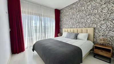 a bedroom with a bed and a large window at Cavalo Branco Portugal in Quarteira