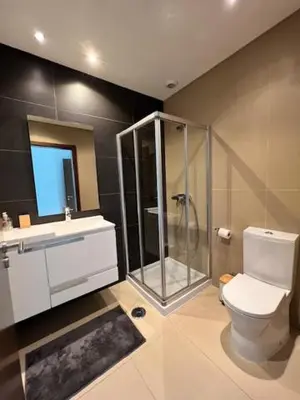 a bathroom with a shower and a toilet and a sink at Cavalo Branco Portugal in Quarteira