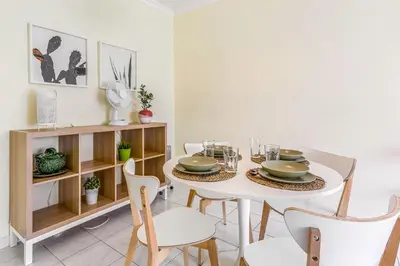 a dining room with a white table and chairs at 1BR Infante Flat in Quarteira by LovelyStay in Quarteira