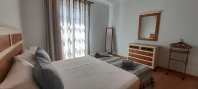 a bedroom with a large bed with a mirror and a dresser at Casa da Travessa - casa de férias no coração de Faro in Faro