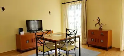 a dining room with a table and a tv at Casa da Travessa - casa de férias no coração de Faro in Faro