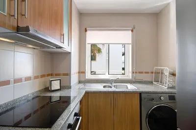 a kitchen with a sink and a washing machine at Ae Flat Falesia in Albufeira