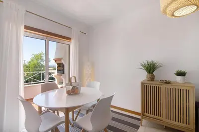 a white dining room with a white table and chairs at Ae Flat Falesia in Albufeira
