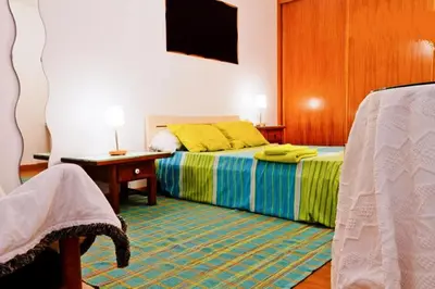 a bedroom with a bed and a table and a television at Coloured Studio in Faro