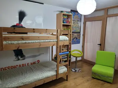 a room with two bunk beds and a green chair at Coloured Studio in Faro