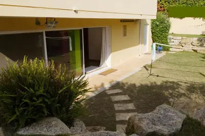 a house with a porch and a yard with rocks at Coloured Studio in Faro