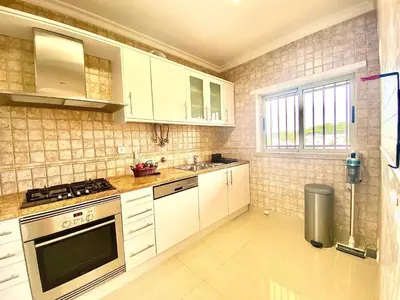 a kitchen with white cabinets and a stove at Vilamoura Avelãs Ocean View Apartment in Vilamoura