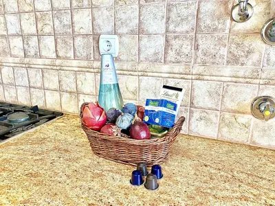 a basket of vegetables and a bottle on a counter at Vilamoura Avelãs Ocean View Apartment in Vilamoura