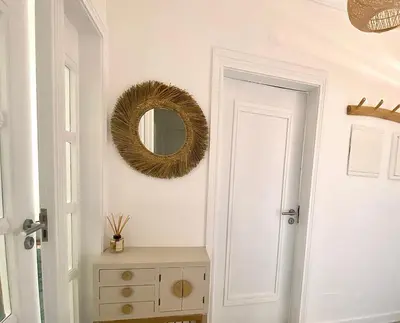 a hallway with a mirror and a dresser next to a door at Vilamoura Avelãs Ocean View Apartment in Vilamoura