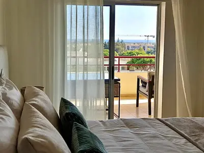 a bedroom with a bed and a view of a balcony at Vilamoura Avelãs Ocean View Apartment in Vilamoura