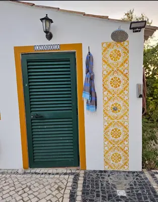 a building with a green door and a wall with tiles at Casa Aventura in Boliqueime
