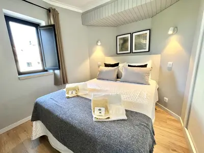 a bedroom with a large bed with two trays on it at Porto Marina - City center by HD PROPERTIES in Vilamoura