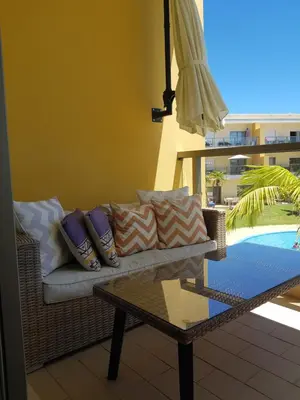 a couch on a patio with a table and an umbrella at MARINA DE ALBUFEIRA, Best Apartment in Albufeira