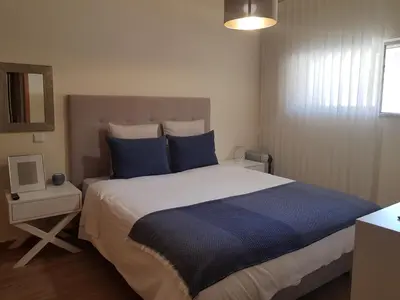a bedroom with a large bed with blue pillows at MARINA DE ALBUFEIRA, Best Apartment in Albufeira