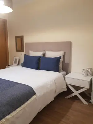 a bedroom with a large bed with blue pillows at MARINA DE ALBUFEIRA, Best Apartment in Albufeira