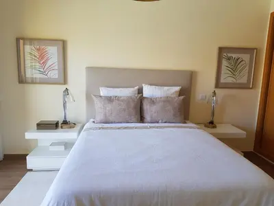 a bedroom with a large white bed with two tables at MARINA DE ALBUFEIRA, Best Apartment in Albufeira