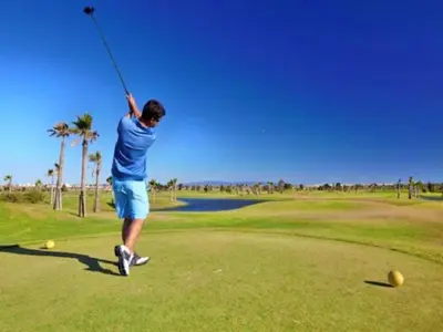 a man swinging a golf club on a golf course at Cozy Townhouse Vila Rafaella2 near São Rafael Beach Albufeira in Albufeira