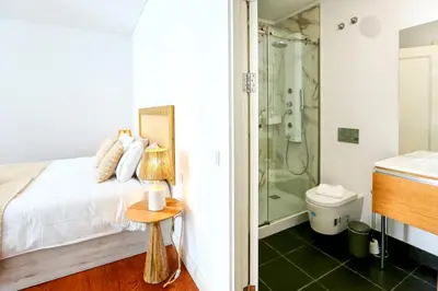 a bathroom with a bed and a shower and a table at Algarve Sweetness Apartment in Faro