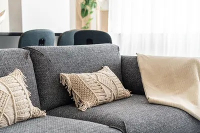 a gray couch with two pillows on it at Privilege Deluxe Apartment Casa Mãe, Faro in Faro