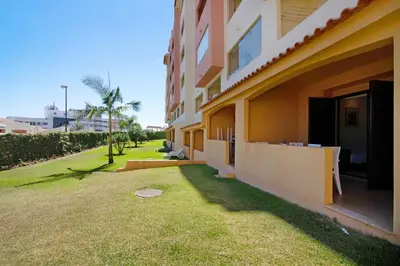 a building with a grass yard next to a building at Belavista House in Albufeira