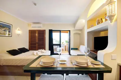 a room with a bed and a table with plates and wine glasses at Belavista House in Albufeira