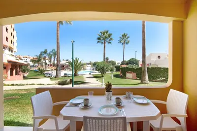 a white table with white chairs and a large window at Belavista House in Albufeira