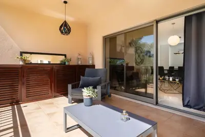 a kitchen with wooden cabinets and a table in it at Love Nest Algarve Edition vilamoura in Vilamoura