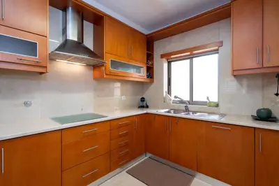 a kitchen with wooden cabinets and stainless steel appliances at Love Nest Algarve Edition vilamoura in Vilamoura