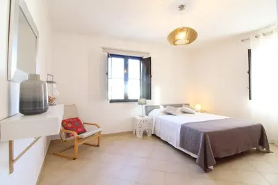 a bedroom with a bed and a chair and a window at Old Town Oasis 110m to Beach, AC & 2 Bathrooms by Vou de Férias in Albufeira