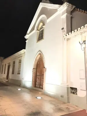 a white church with a large door in the night at Old Town Oasis 110m to Beach, AC & 2 Bathrooms by Vou de Férias in Albufeira