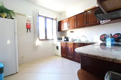 a kitchen with wooden cabinets and a counter top at Old Town Oasis 110m to Beach, AC & 2 Bathrooms by Vou de Férias in Albufeira