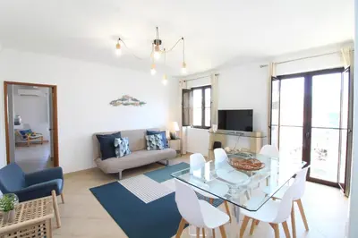 a living room with a glass table and white chairs at Old Town Oasis 110m to Beach, AC & 2 Bathrooms by Vou de Férias in Albufeira