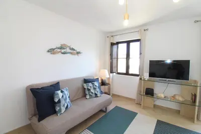 a living room with a couch and a tv at Old Town Oasis 110m to Beach, AC & 2 Bathrooms by Vou de Férias in Albufeira