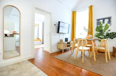 a dining room with a table and chairs and a mirror at Beach Waves Apartment in Faro
