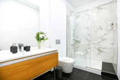 a bathroom with a shower and a toilet and a sink at Beach Waves Apartment in Faro