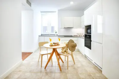 a kitchen with a table and chairs in a room at Coast Guard Apartment in Faro