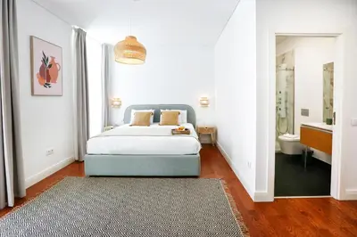 a bedroom with a bed and a bathroom at Endless Summer Apartment in Faro