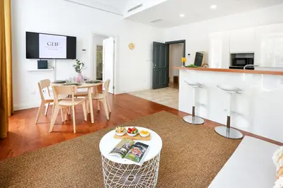 a living room with a table and a kitchen at Endless Summer Apartment in Faro
