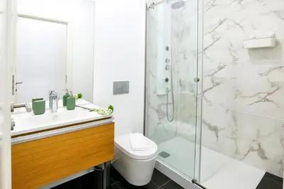 a bathroom with a shower and a toilet and a sink at Faro Away From Home Apartment in Faro