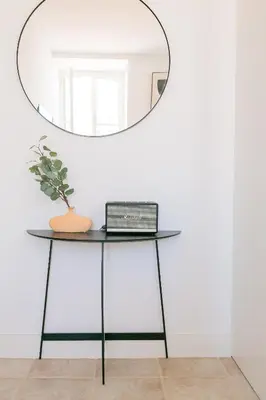 a table with a mirror on a white wall at President Pais Apartment in Faro