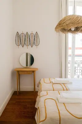 two beds in a room with a mirror and a table at President Pais Apartment in Faro