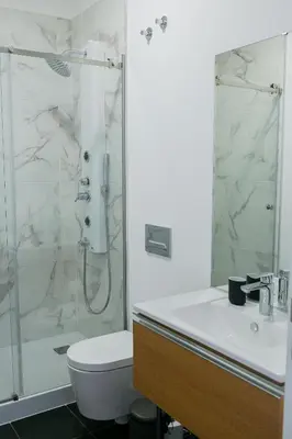 a bathroom with a shower and a toilet and a sink at President Pais Apartment in Faro