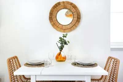 a white dining room table with a mirror on the wall at Salty Spot Apartment in Faro