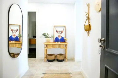 a hallway with a mirror and a table with a deer picture at Xtraordinary Moments Apartment in Faro