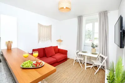 a living room with a red couch and a table with a bowl of fruit at Xtraordinary Moments Apartment in Faro