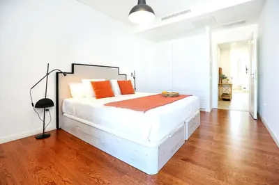 a bedroom with a large white bed with orange pillows at Xtraordinary Moments Apartment in Faro