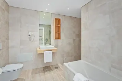 a bathroom with a tub and a toilet and a sink at Balaia Senses in Albufeira